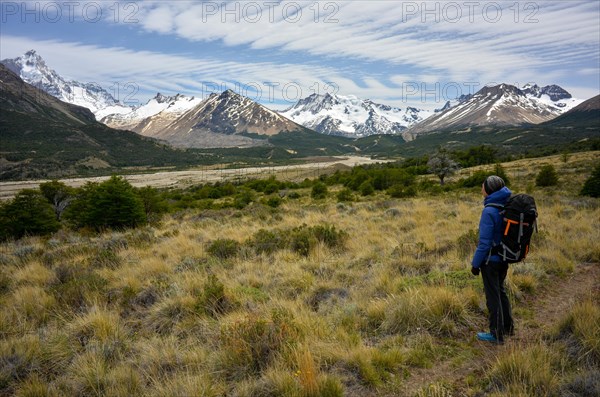 Hiker enjoying the view of the mountains and glaciers of the Patagonian Andes with Monte San