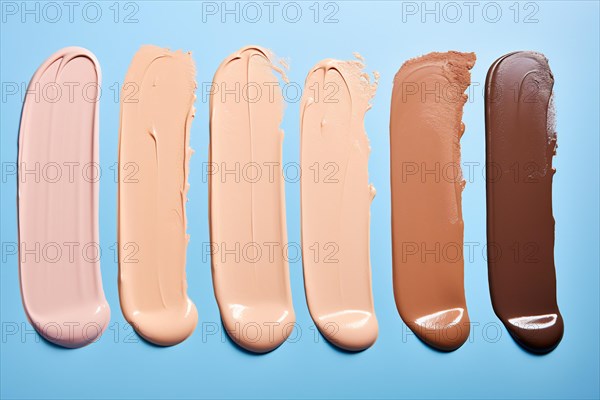Different makeup foundation swatches for caucasian and black skin tones on blue background. KI