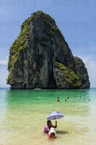 Man and child with parasol in the sun in the sea, ocean, sunshade, Andaman Sea, ozone, heat,