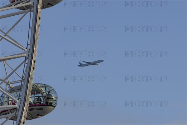 Aircraft of Korean airways in flight behind the pods of the London Eye or Millennium Wheel, London,