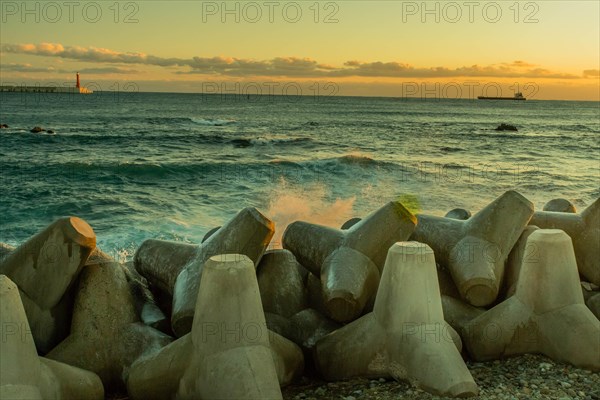 Seascape with concrete tetrapods on breakwater during dusk, creating a tranquil scene, in South
