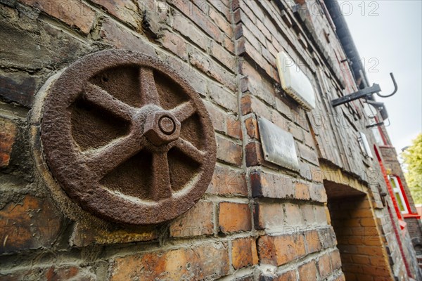 Metal rusted ankra protects house from damage on wobbly post-mining land, Katowice, Nikiszowiec,