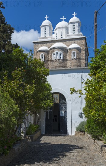 A white church and three domes rise between trees, Byzantine fortress, nunnery, monastery, Koroni,