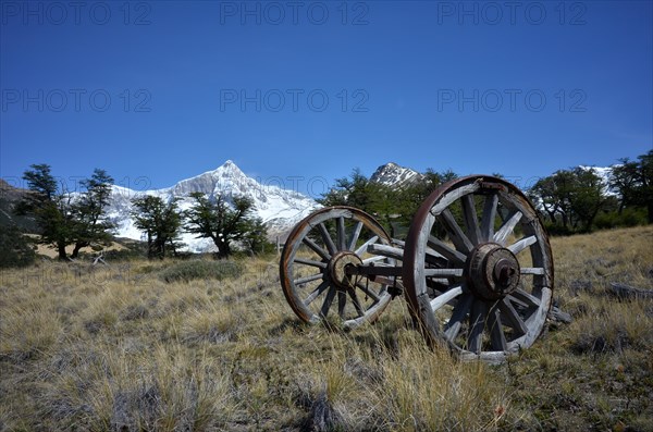 Old wooden cart in front of the snow-covered Monte San Lorenzo, Perito Moreno National Park,