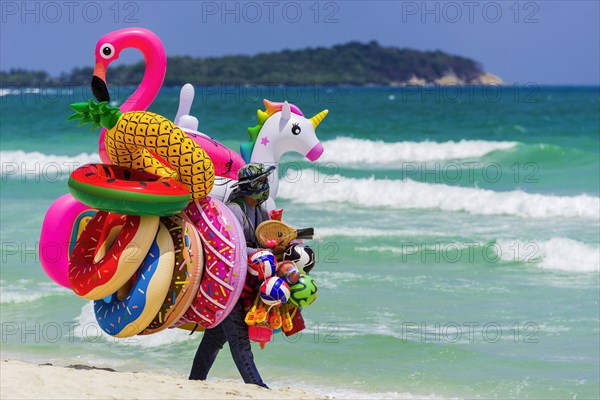 Merchant on the beach selling inflatable swimming aids, colourful, swimming, beach vendor, holiday,