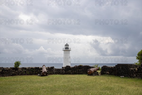 White lighthouse on a steep coast. Dramatic clouds with a view of the sea, pure Caribbean at Le