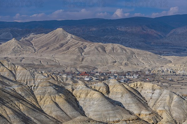 Lo Manthang, capital of Upper Mustang, viewed from a distance amidst a barren desertic landscape,
