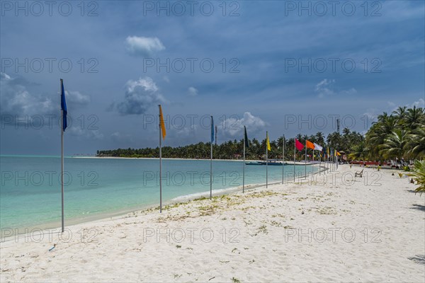 White sand beach with many flags, Bangaram island, Lakshadweep archipelago, Union territory of