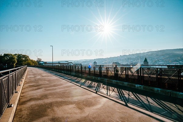 Morning atmosphere on an empty bridge with a view of the city in the warm sunlight, cycle path,
