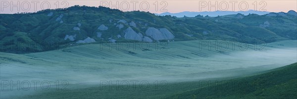 Early morning fog shortly in front of sunrise in the Crete Senesi, Province of Siena, Tuscany,
