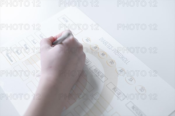 Diabetes log, daily log of food and insulin administration, food log, hand of a child holding a pen