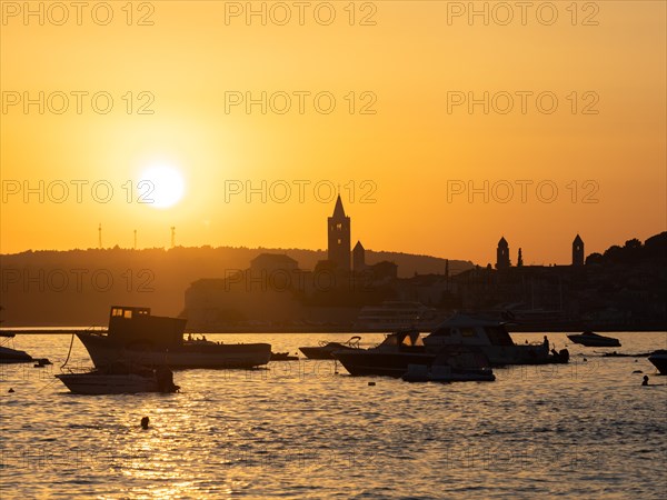 Boats anchoring in a bay, silhouette of a church tower, sunset over Rab, town of Rab, island of