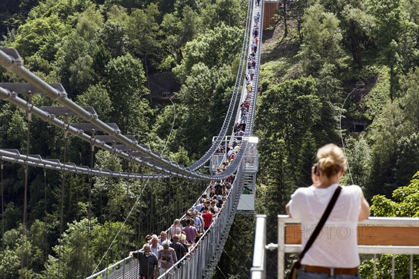 Visitors cross the rope suspension bridge at the Rappbode dam, 483 metres long, 100 metres above