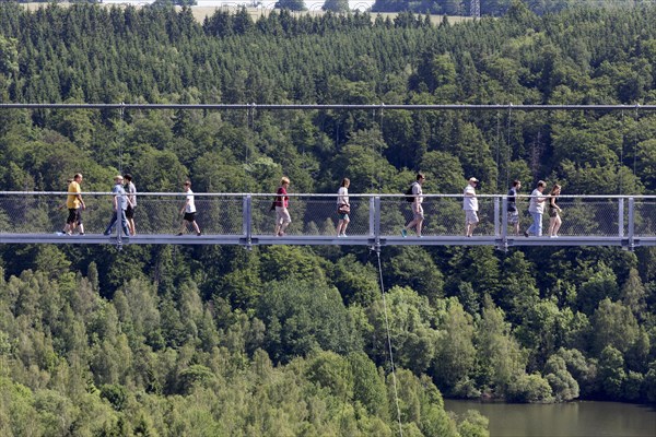 Visitors cross the rope suspension bridge at the Rappbode dam, 483 metres long, 100 metres above