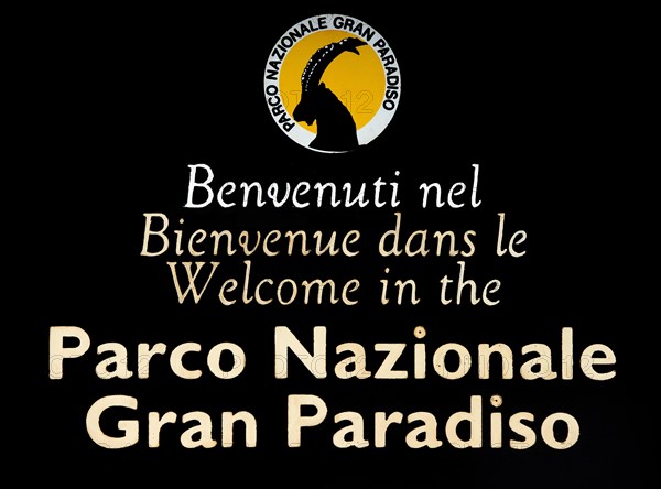 Wooden welcoming board with logo of the Gran Paradiso National Park in the Graian Alps, Italy,