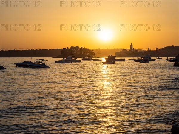 Boats anchoring in a bay, silhouette of a church tower, sunset over Rab, town of Rab, island of