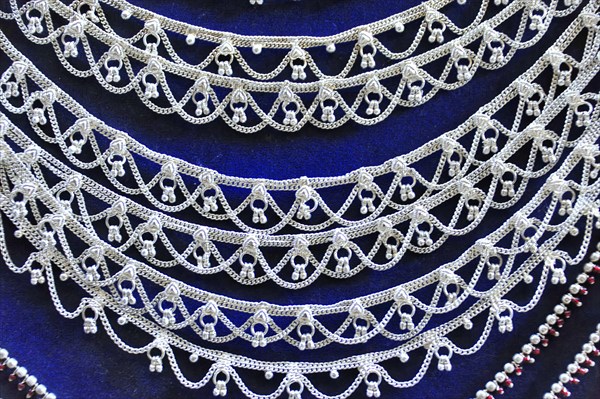Silver jewellery necklaces with detailed patterns on a dark background, Varanasi, Uttar Pradesh,