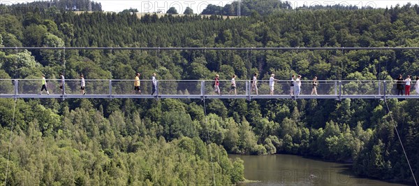 Visitors cross the rope suspension bridge at the Rappbode dam, 483 metres long, 100 metres above