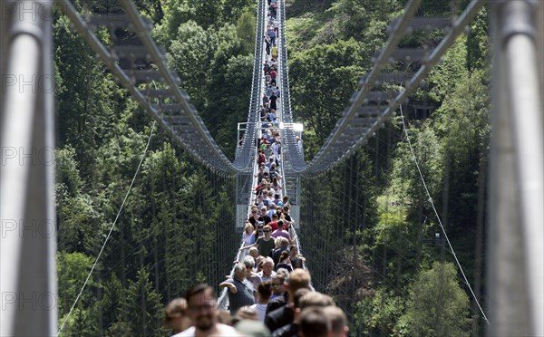 Visitors cross the rope suspension bridge at the Rappbode dam, 483 metres long, 100 metres above