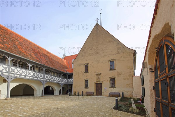 Hospital with arcade and hospital church, historic half-timbered house, inner courtyard,