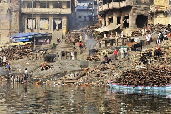 Varanasi Ghats with logs for cremation rituals along the river, Varanasi, Uttar Pradesh, India,