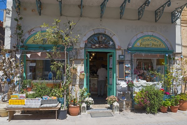 An inviting bookshop with an open door and a wide variety of articles in the entrance area, Koroni