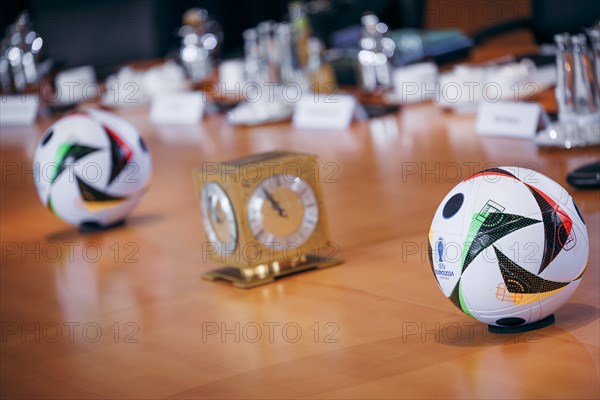 Two footballs lie on the cabinet table during a cabinet meeting at the Federal Chancellery in