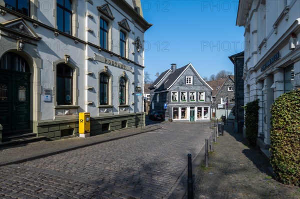 A deserted street surrounded by traditional half-timbered architecture on a clear day, Graefrath,