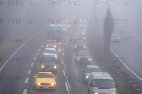Cars driving on a foggy road with poor visibility in the grey daylight, Magdeburg, Saxony-Anhalt,