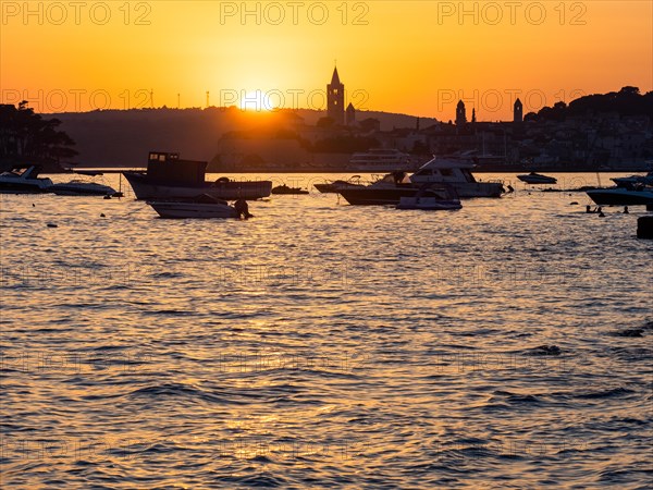Boats anchoring in a bay, silhouette of a church tower, sunset over Rab, town of Rab, island of
