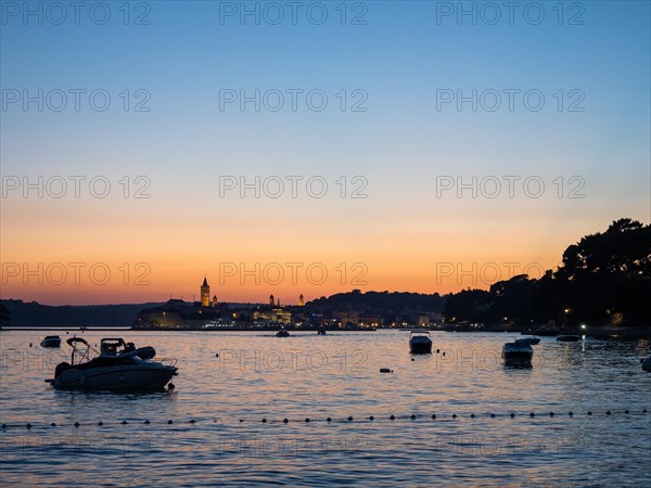 Boats anchoring in a bay, church towers, sunset over Rab, town of Rab, island of Rab, Kvarner Gulf
