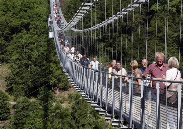 Visitors cross the rope suspension bridge at the Rappbode dam, 483 metres long, 100 metres above