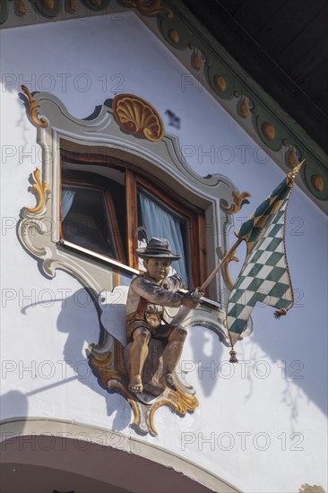 Wooden figure of a boy in lederhosen with Bavarian diamond flag white-blue at the Fraundorfer Inn,