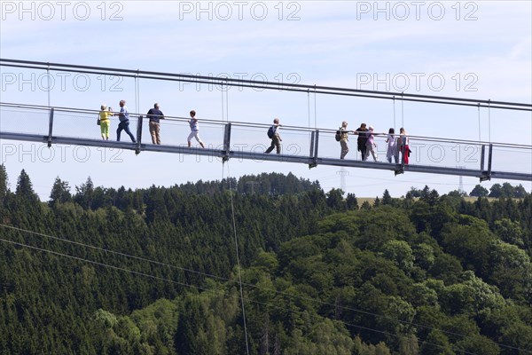 Visitors cross the rope suspension bridge at the Rappbode dam, 483 metres long, 100 metres above