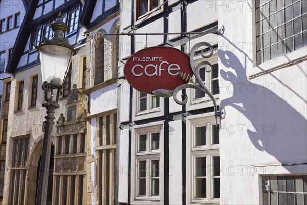 Historic facades, lantern and sign for the museum cafe in backlighting in the Schnurrviertel in the