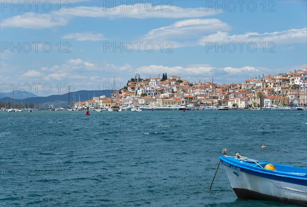 View of a picturesque Mediterranean town with boats and a lively waterfront promenade, Poros, Poros