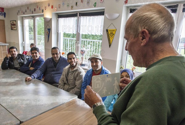 Syrian refugees learn traffic rules during an integration course. An employee of the