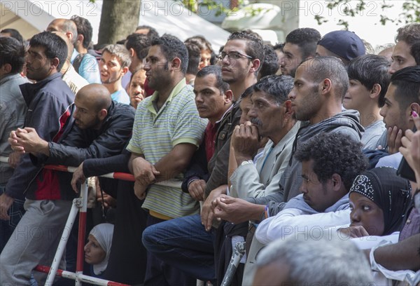 Refugees from Syria wait behind barriers in the central reception centre for asylum seekers at the
