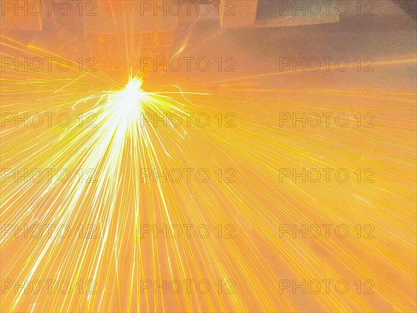 Close up of sparks fly out machine head for metal processing at the factory. Automotive production