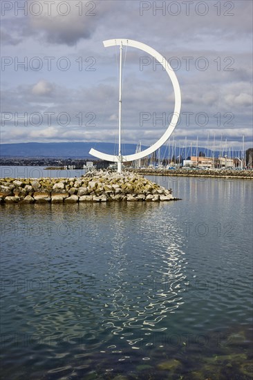 Large, semi-circular wind vane Eole, a sculpture by the artist Clelia Bettua within the harbour of