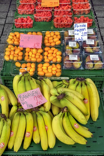 A fruit stand with figs, raspberries, kumquats (Fortunella), and bananas in mid-March, Kempten,