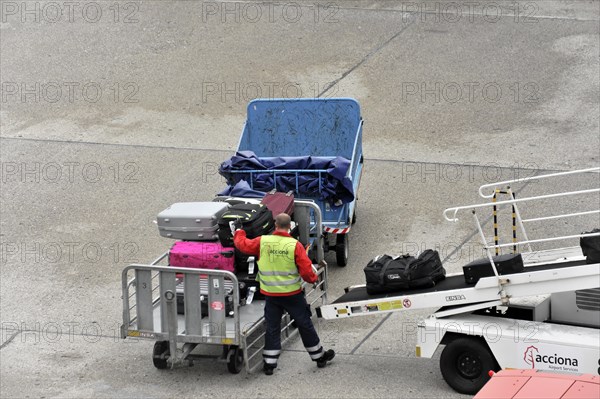 Airport employee operating a luggage trolley on the tarmac, Hamburg, Hanseatic City of Hamburg,