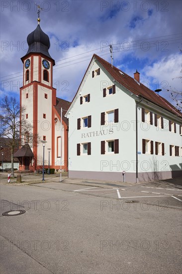 St John's Church and town hall under a blue sky with white cumulus clouds in Bad Krozingen,
