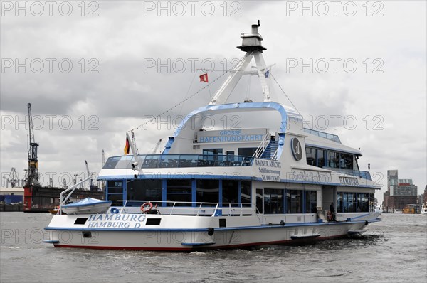An excursion boat with a blue hull and white superstructure sails through Hamburg harbour, Hamburg,