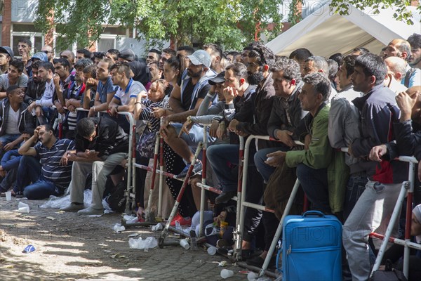 Refugees from Syria wait behind barriers in the central reception centre for asylum seekers at the