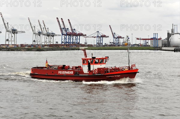 A red fire boat sailing through the water in Hamburg harbour, Hamburg, Hanseatic City of Hamburg,