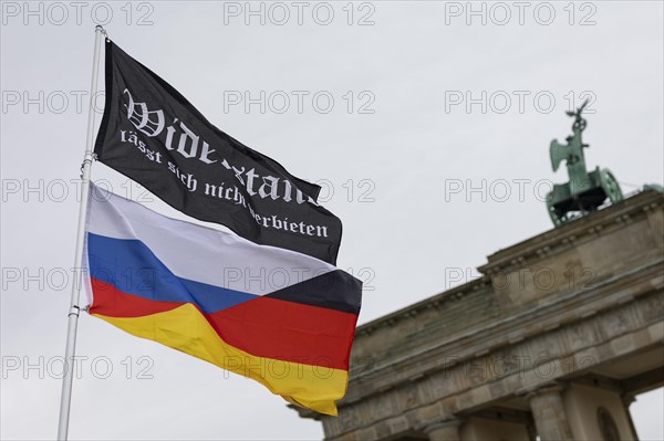 A waving flag with the inscription 'AeoeWiderstand laesst sich nicht verbieten'Aeo and a