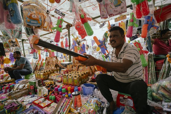 Vendor sells Holi celebration items in a street market, ahead of Holi festival on March 23, 2024 in