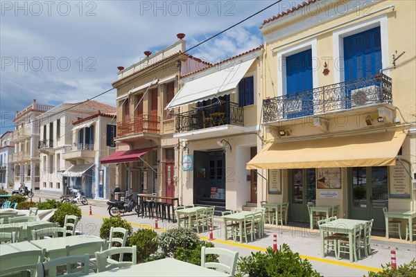 Mediterranean street with colourful buildings, an outdoor restaurant and a clear blue sky,