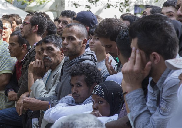 Refugees from Syria wait behind barriers in the central reception centre for asylum seekers at the